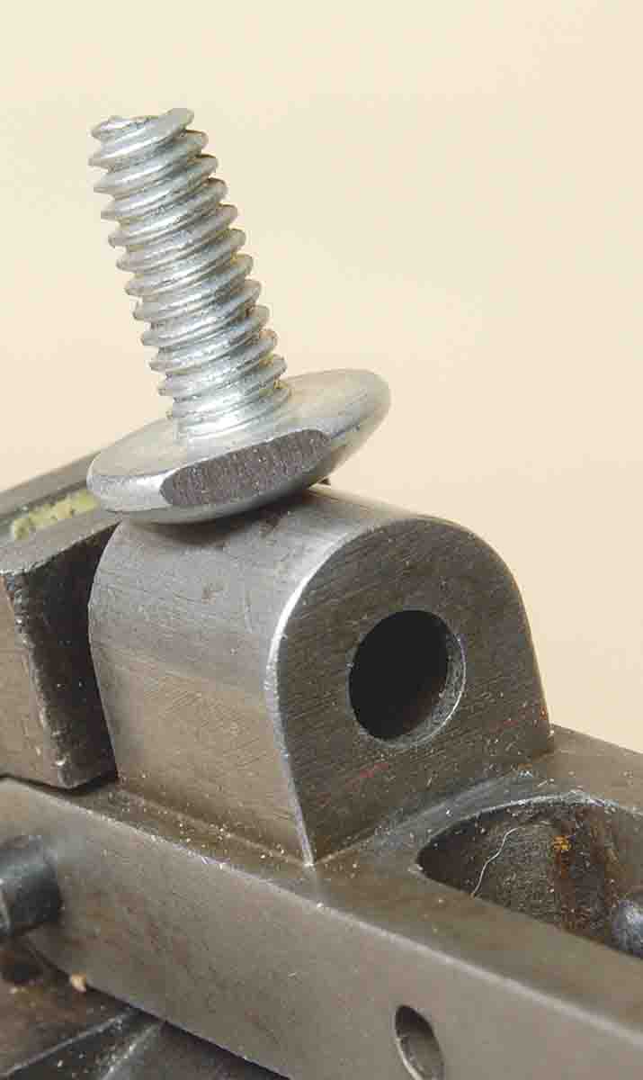 The rear of the trigger return spring housing showing the hole and machine screw sitting on top.